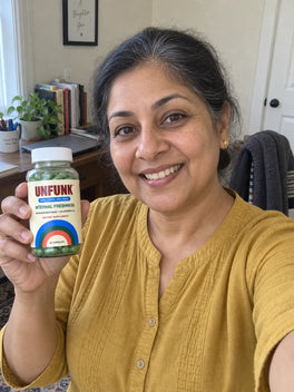 Woman in a mustard top holding UNFUNK, at her home office